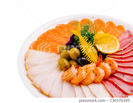 Delicious seafood platter featuring fresh sashimi and garnishes Delicious seafood platter featuring fresh sashimi and garnishes 130376395