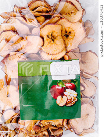 Dried apple slices packaged for easy snacking in a clear bag 130376412