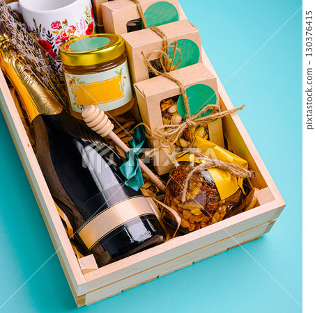 Gift basket with champagne, snacks, and decorative items for celebrations 130376415