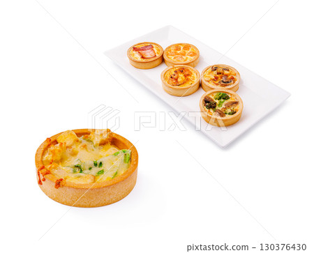 Variety of savory tarts served on a platter at a casual dining setting 130376430