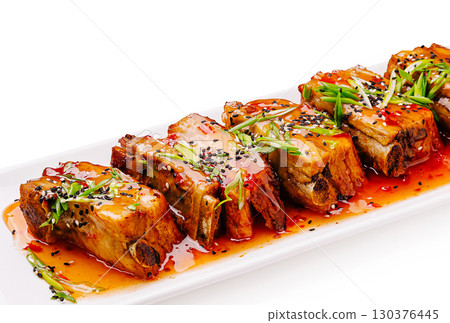 Deliciously presented pork belly drizzled with spicy sauce and garnishes 130376445