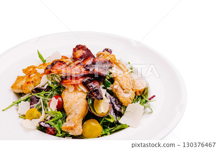 Delicious chicken salad with greens, bacon, and cheese on a white plate Delicious chicken salad with greens, bacon, and cheese on a white plate 130376467