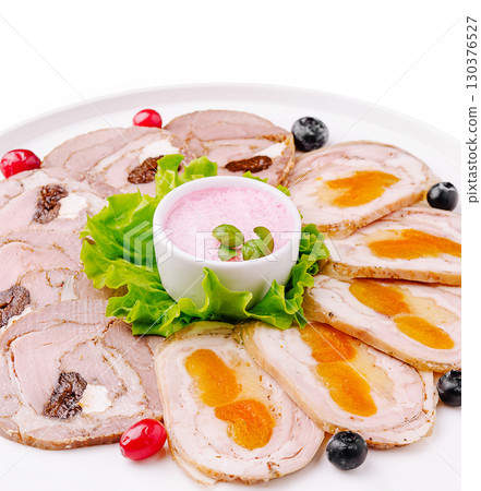 Beautifully arranged platter of sliced meat with colorful garnishes Beautifully arranged platter of sliced meat with colorful garnishes 130376527