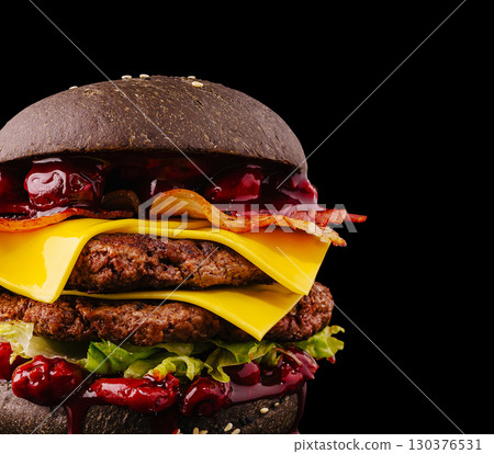 Juicy gourmet burger with unique toppings and striking black bun Juicy gourmet burger with unique toppings and striking black bun 130376531