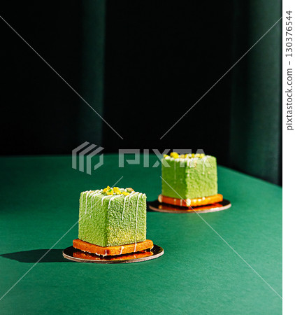 Unique green desserts displayed on a stylish green table in a modern setting 130376544