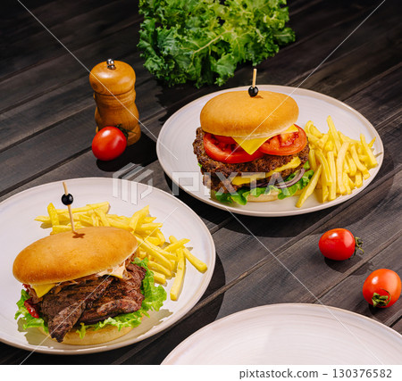 Tasty burgers with fries and fresh veggies in a casual setting 130376582