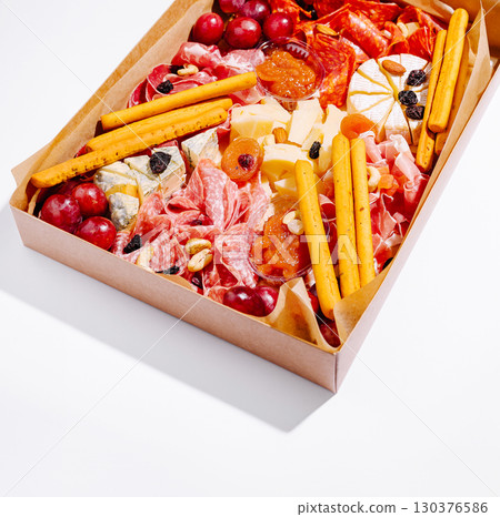 Gourmet charcuterie board with meats, cheeses, and fruits for parties 130376586