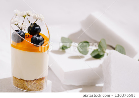 Delicious dessert with orange topping and fresh berries on a white background Delicious dessert with orange topping and fresh berries on a white background 130376595