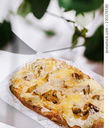 Delicious open-faced sandwich topped with melted cheese and mushrooms 130376596