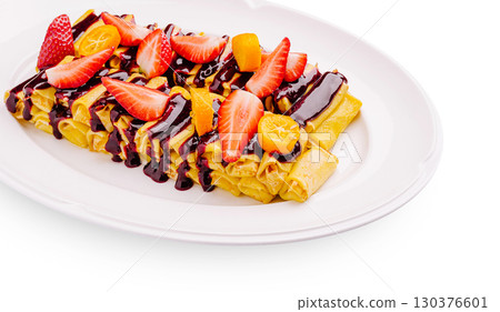 Delicious crepes topped with fresh fruit and chocolate sauce 130376601