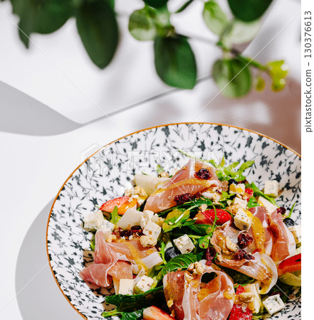 Colorful salad with fresh ingredients served in artistic bowl 130376613