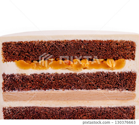 Chocolate cake layers with creamy filling and a nutty topping 130376663