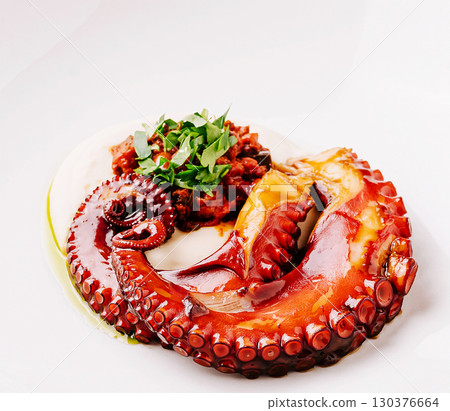 Freshly prepared octopus dish served with savory sauce and herbs 130376664