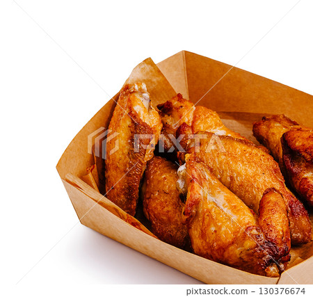 Crispy chicken wings served in a takeout box for a delicious snack 130376674