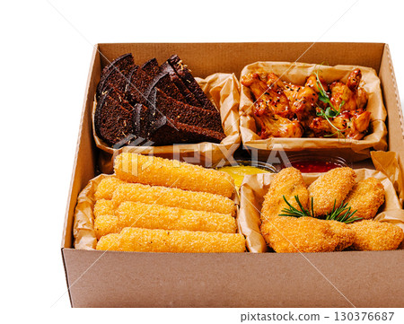 Delicious platter of crispy snacks featuring wings, cheese sticks, and bread Delicious platter of crispy snacks featuring wings, cheese sticks, and bread 130376687