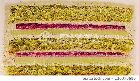 Colorful dessert layers featuring green and red fillings on a white base Colorful dessert layers featuring green and red fillings on a white base 130376696