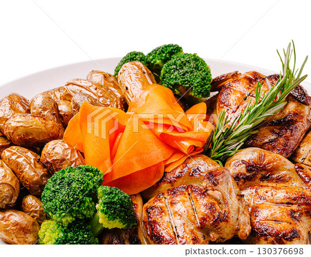 Delicious grilled chicken with vegetables and baked potatoes served on a platter Delicious grilled chicken with vegetables and baked potatoes served on a platter 130376698
