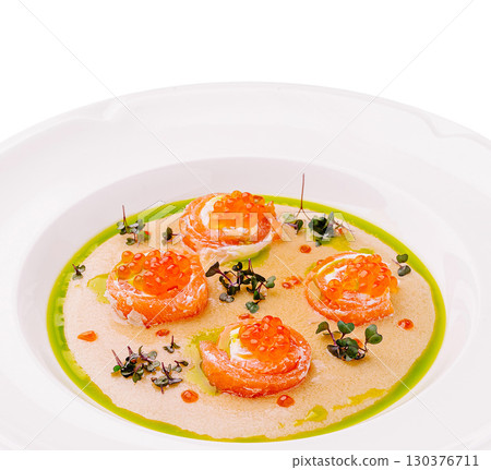 Delicate salmon rolls served in a gourmet dish with vibrant sauce 130376711