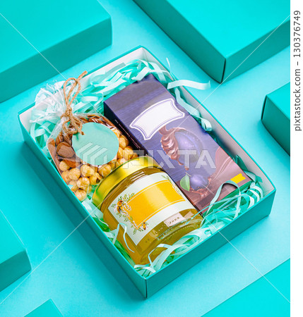 Beautiful gift box filled with treats arranged on a colorful bac Beautiful gift box filled with treats arranged on a colorful bac 130376749