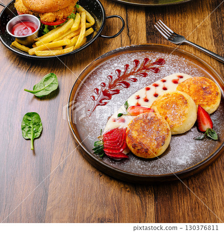 Delicious dessert plate with strawberries and cream on wooden table Delicious dessert plate with strawberries and cream on wooden table 130376811