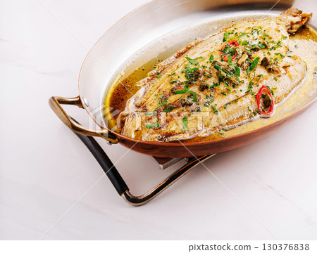 Deliciously cooked whole fish garnished with fresh herbs and spi 130376838