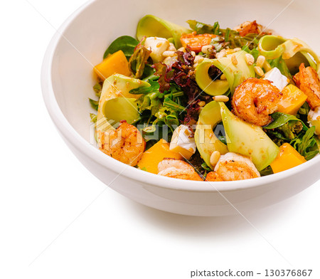 Fresh shrimp salad with mango and greens served in a white bowl 130376867