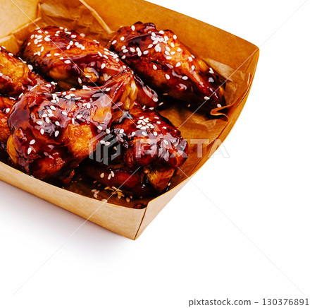 Delicious glazed chicken wings with sesame seeds served in a basket Delicious glazed chicken wings with sesame seeds served in a basket 130376891