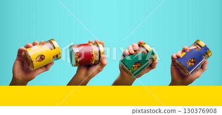 Colorful jars of granola held by hands against a bright blue background Colorful jars of granola held by hands against a bright blue background 130376908