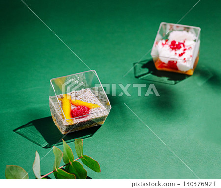 Vibrant dessert cups with fresh fruits and creamy toppings 130376921