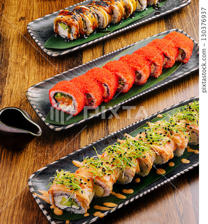 Artfully arranged sushi rolls on wooden table in Japanese restau 130376937