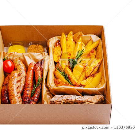 Grilled sausages and roasted potatoes in a takeout box for outdoor dining Grilled sausages and roasted potatoes in a takeout box for outdoor dining 130376950