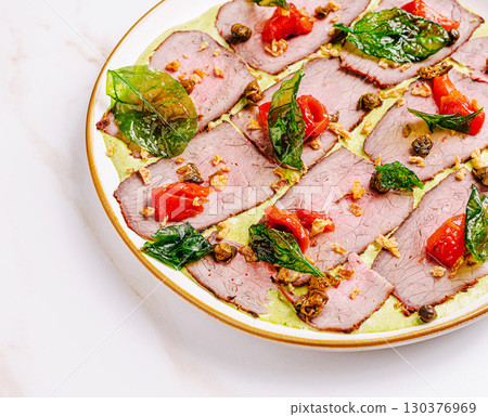 Savory meat platter with fresh herbs and tomatoes on a white background Savory meat platter with fresh herbs and tomatoes on a white background 130376969