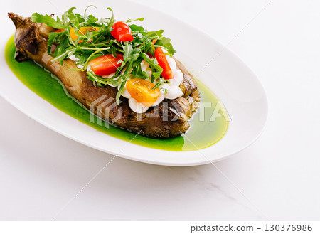 Baked eggplant with arugula and cherry tomatoes Baked eggplant with arugula and cherry tomatoes 130376986