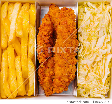 Crispy chicken strips with golden fries and fresh cabbage slaw served in a box Crispy chicken strips with golden fries and fresh cabbage slaw served in a box 130377003