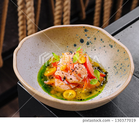 Fresh salmon dish with herbs and citrus in a unique bowl presentation 130377019