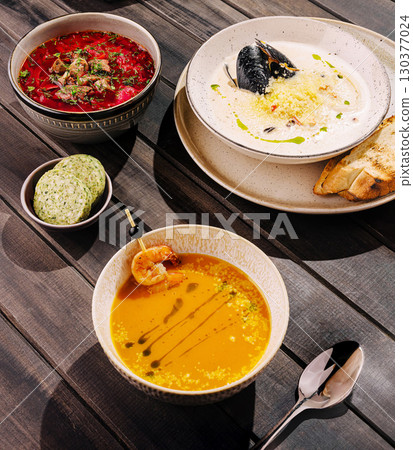 Delicious seafood and soup dishes presented on rustic wooden table Delicious seafood and soup dishes presented on rustic wooden table 130377024