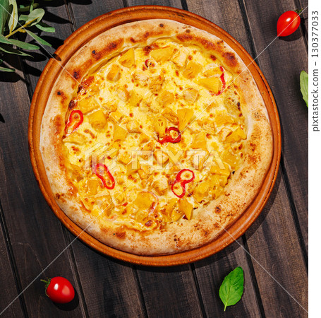 Delicious pizza topped with mango, cheese, and chili on wooden table 130377033