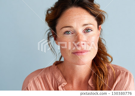 Woman with glowing skin poses against a pastel background showcasing natural beauty and serenity 130380776