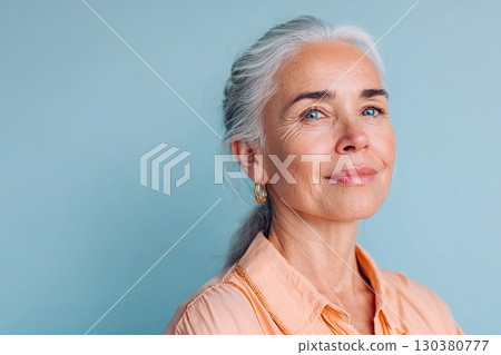 Woman with glowing skin poses against a pastel background during daytime indoors 130380777