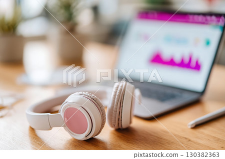 Notebook and pen on a desk with laptop and headphones for productive work environment Notebook and pen on a desk with laptop and headphones for productive work environment 130382363