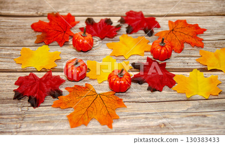 Autumn leaves and pumpkins on rustic wood 130383433