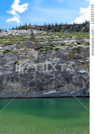 Scenic lake with clear green waters and the mountain with trees. 130383729