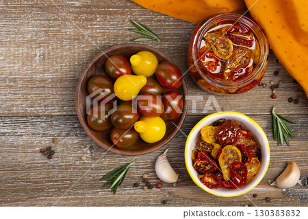 Flatlay of dried cherry tomatoes in a jar and plate with ingredients. Flatlay of dried cherry tomatoes in a jar and plate with ingredients. 130383832