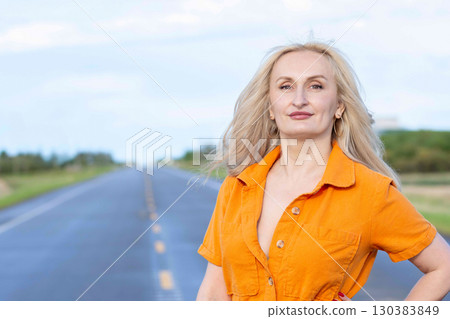 Blonde free woman is on the empty rural road in summer. Blonde free woman is on the empty rural road in summer. 130383849