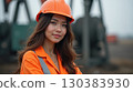 Asian female oilfield technician is at work at the pumpjack. 130383930