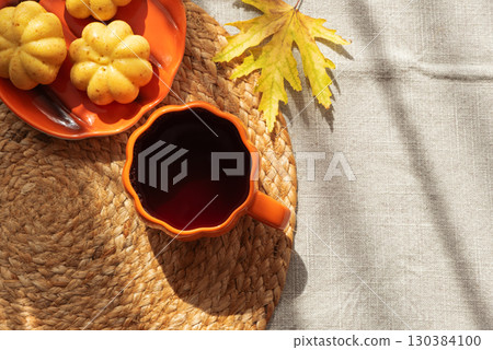 Pumpkin Mug and Mini Cakes with Autumn Leaf on Woven Placemat 130384100