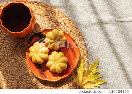 Pumpkin Mug and Mini Cakes with Autumn Leaf on Woven Placemat Pumpkin Mug and Mini Cakes with Autumn Leaf on Woven Placemat 130384103