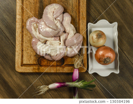 Cow bowels presented on a wooden board with ingredients, ready to grill 130384196
