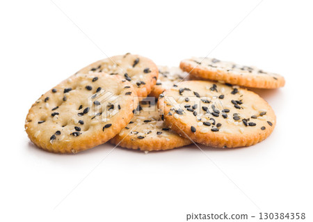 Crispy round salted crackers with sesame seeds isolated on white background. 130384358