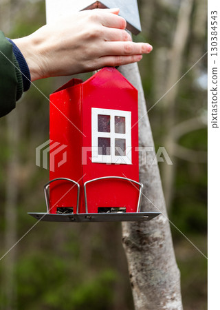 The red, swedish cottage shaped bird feeder. 130384543